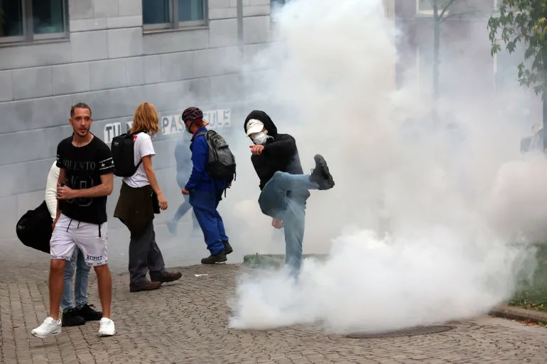 Manifestantes reaccionan al gas lacrimógeno durante la protesta estudiantil en Liège, Bélgica, el 7 de octubre de 2026.